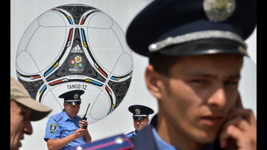 Police officers stand in front of a poster showing a giant ball.