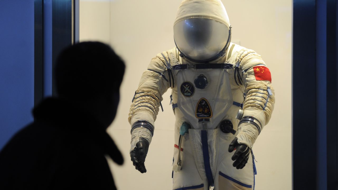 A visitor at the Shanghai Science & Technology Museum looks at a spacesuit used by Chinese astronauts.