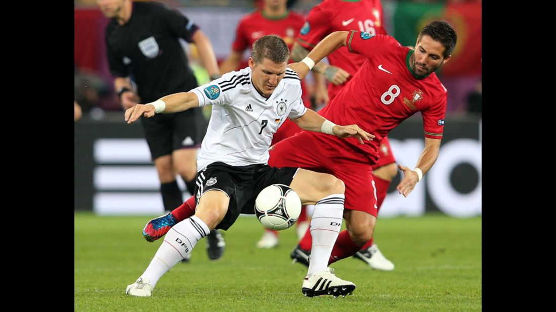 Bastian Schweinsteiger of Germany holds off a challenge from Joao Moutinho of Portugal.