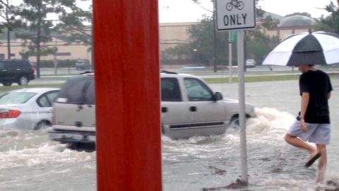 Cars attempt to navigate high water Sunday in Escambia County, Florida.