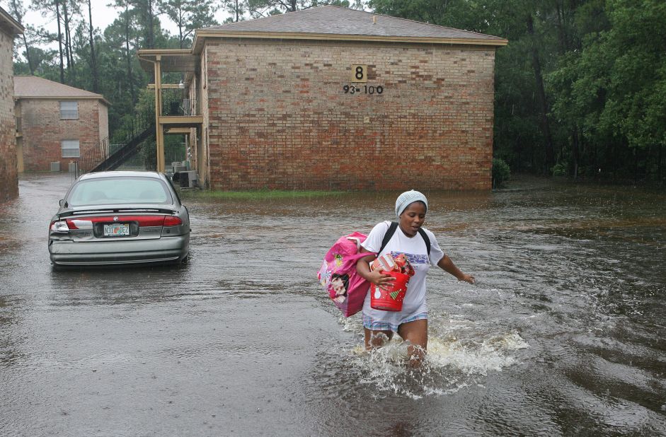 Scoobi Griffin  splashes through the parking lot of her flooded Pensacola complex Sunday.