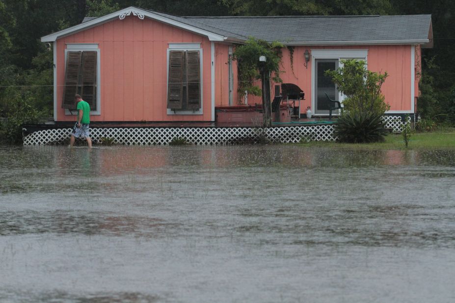 Josh Spinner checks his home surrounded by floodwaters Sunday in Perdido, Florida.
