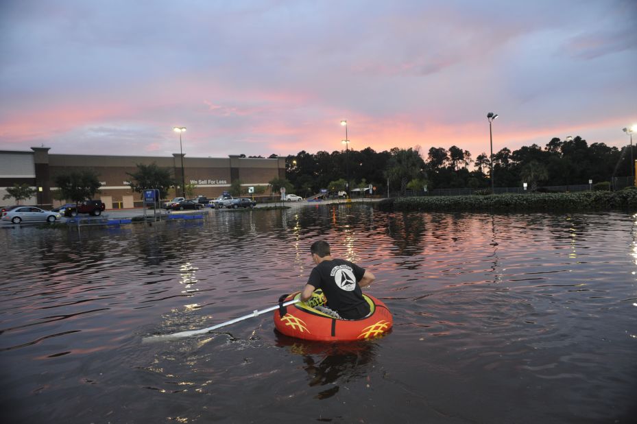 Robby Mandel, 16, navigates a flooded parking lot in Pensacola, Florida, on Saturday, June 9, as torrential rains inundate the Florida Panhandle and coastal Alabama. 