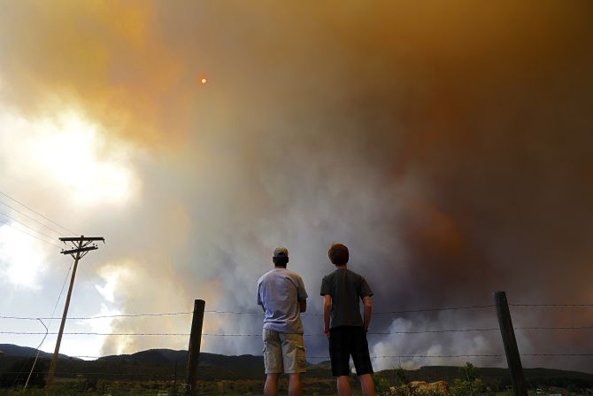Robby Wood, left, of Denver and his 16-year-old nephew, Jacob Wood, watch the thick smoke rise over a hill near Laporte.