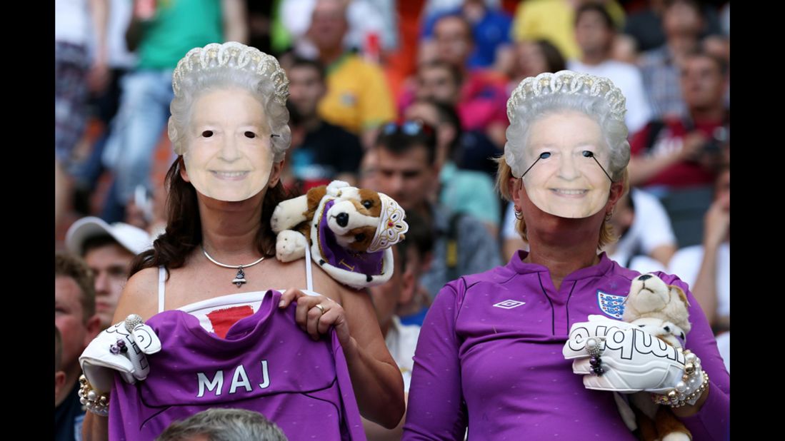 England fans wearing Queen Elizabeth II masks watch the match against France on Monday.