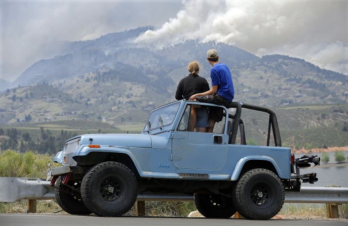 Michelle Mellenthin and Chris Huizenga watch firefighting efforts Monday from a Jeep near Laporte.
