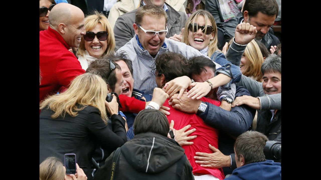 Nadal is embraced by friends and family in the stands after his victory.
