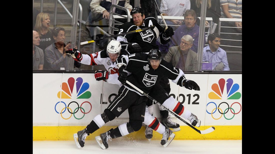 The Devils' Ryan Carter gets checked by Matt Greene and Jordan Nolan of the Kings in the first period.