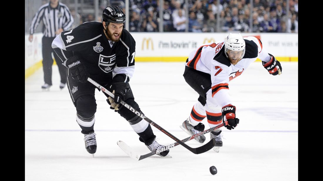 The Kings' Dwight King and the Devils' Henrik Tallinder battle for control of the puck.