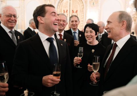 As protests took place nearby, Russia's President Vladimir Putin, right, and Prime Minister Dmitry Medvedev, second left, clink glasses in the Great Kremlin Palace in Moscow.