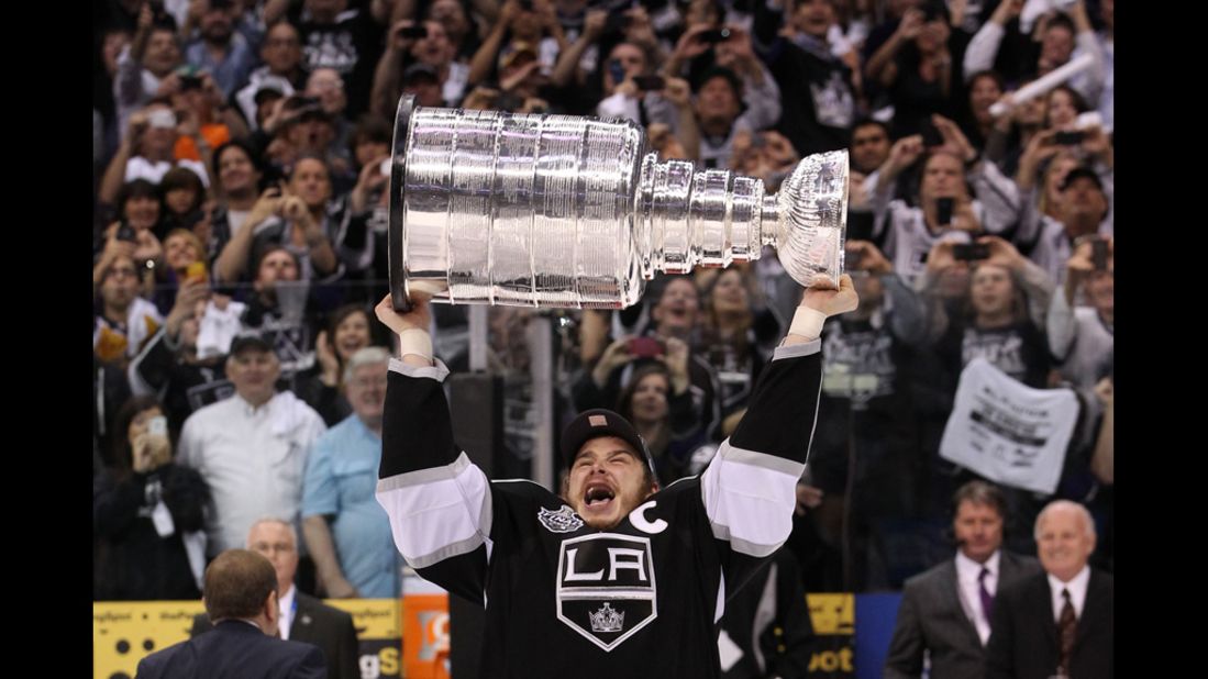 Captain Dustin Brown of the Los Angeles Kings holds up the Stanley Cup after his team defeated the New Jersey Devils 6-1 on Monday, June 11.