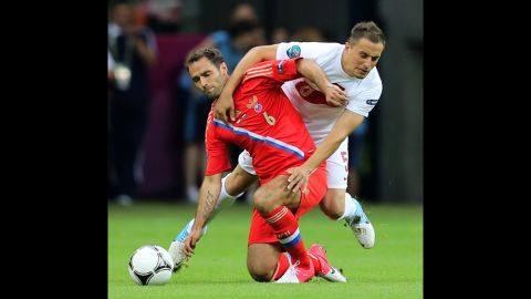 Roman Shirokov of Russia and Dariusz Dudka of Poland vie for control of the ball during their match, Tuesday.