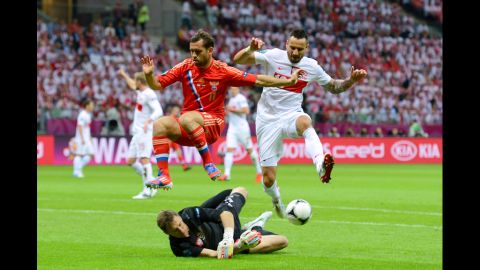 Aleksandr Kerzhakov of Russia and Marcin Wasilewski of Poland jump to avoid colliding with Poland's goalkeeper, Grzegorz Sandomiersk.