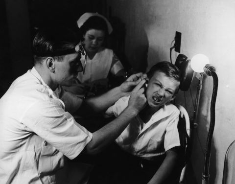 A young patient gets his ears examined in 1935.