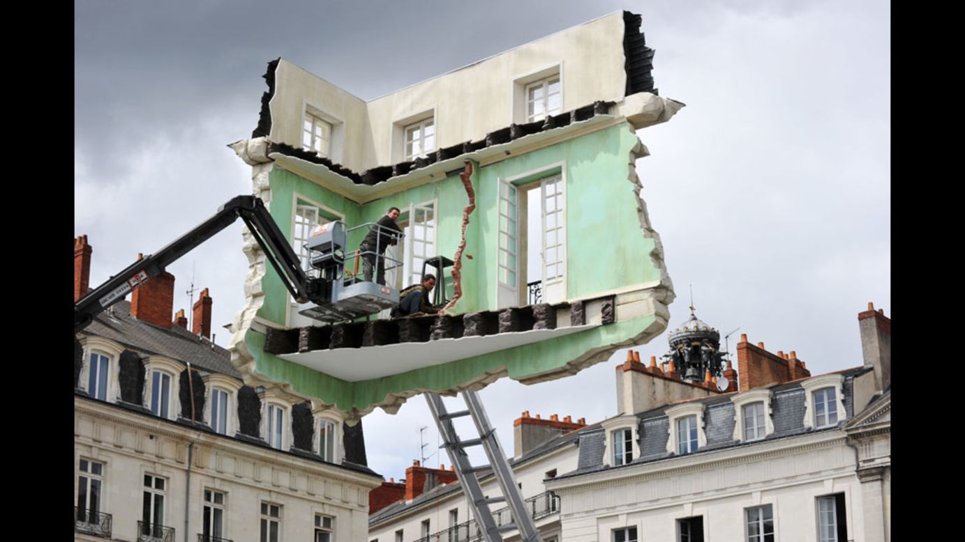 Workers put the final touches on an installation by Argentine artist Leandro Erlich on Wednesday in Nantes, France. It is part of "Le voyage a Nantes," a contemporary art event in 40 stages along Nantes streets.