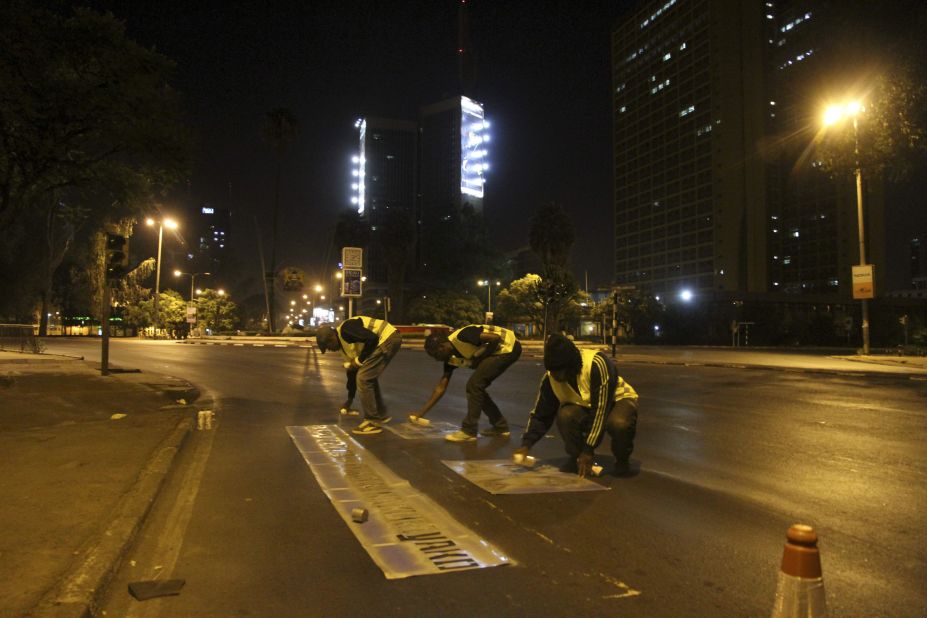 Kenyan graffiti artists put down traffic cones and road markings when they are painting to make the sites appear official.