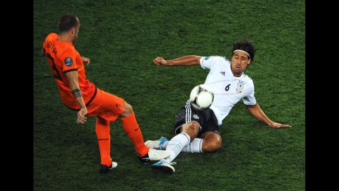 John Heitinga of the Netherlands and Sami Khedira of Germany compete for the ball during the Group B match between Netherlands and Germany. 