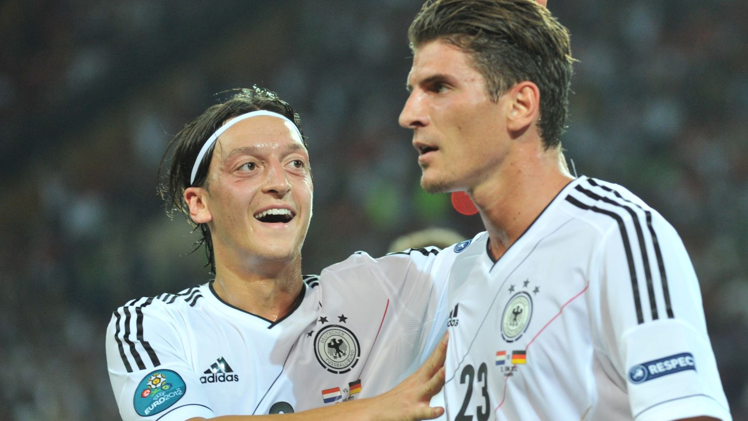 Germany striker Mario Gomez is congratulated by midfielder Mesut Oezil after scoring the first of his two goals