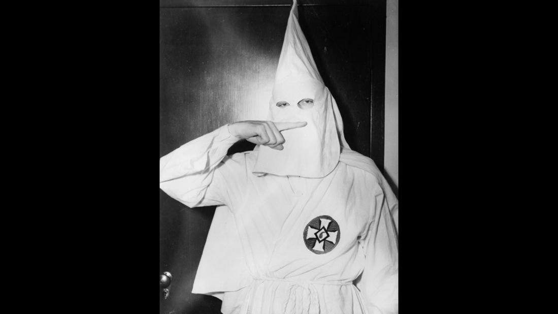 Stetson Kennedy, an activist who infiltrated the Ku Klux Klan and wrote about it in his book Southern Exposure, poses in KKK garb in 1947 and demonstrates the sign for the Oath of Secrecy.