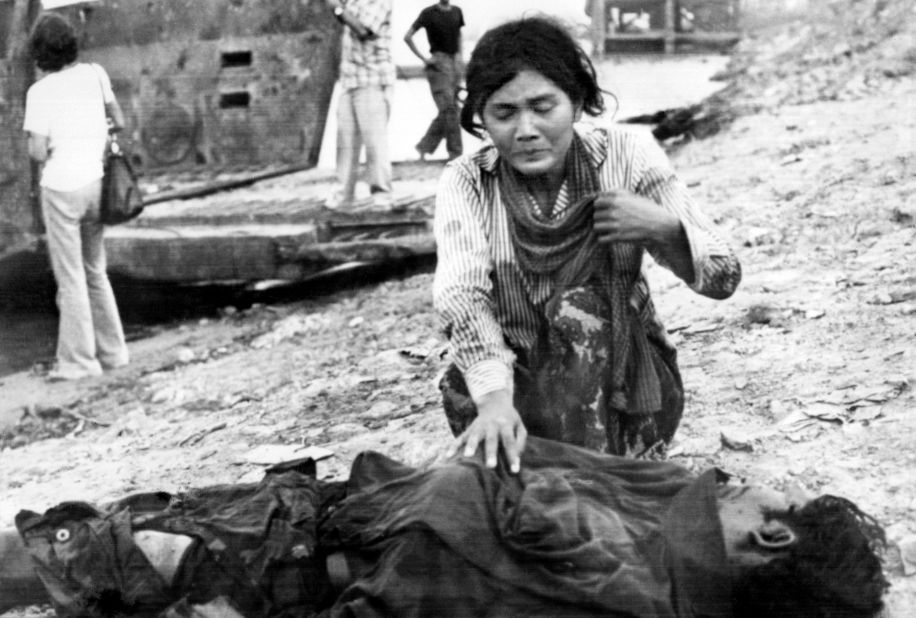 A woman cries next to a dead body on April 17, 1975 in Phnom Penh, after the Khmer Rouge entered the Cambodian capital to establish the government of Democratic Kampuchea.