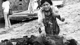 A woman cries next to a dead body, 17 April 1975 in Phnom Penh, after the Khmer Rouge enter the Cambodian capital and establish government of Democratic Kampuchea (DK). (Photo credit should read CLAUDE JUVENAL/AFP/Getty Images) 