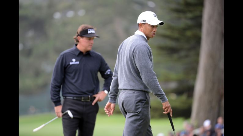 Mickelson and Woods wait on the 11th green.