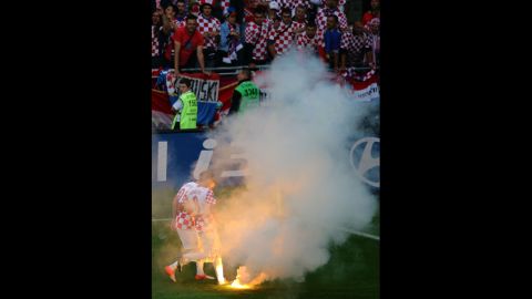 Ognjen Vukojevic and Ivan Perisic of Croatia stand by after a flare was thrown onto the field.