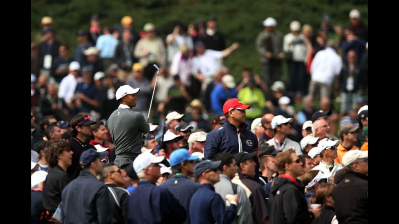 Surrounded by spectators, Woods watches a shot on the 18th tee.