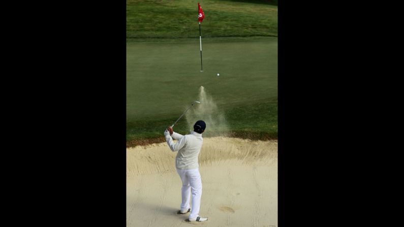 Andy Zhang, a 14-year-old originally from China, hits a bunker shot on the second hole.