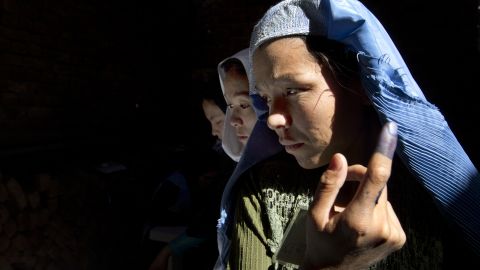 An Afghan woman shows off her ink-stained finger before casting a vote in Kabul in elections in September 2010.