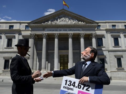 Activists stage a performance depicting Prime Minister Mariano Rajoy and a banker outside the Congress of Deputies in Madrid on June 12, 2012. The demonstration came days after Spain secured a eurozone banking bailout of €100 billion euros ($125 billion).