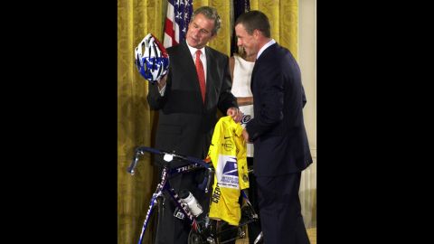 After winning the 2001 Tour de France, Armstrong presents President George W. Bush with a U.S. Postal Service yellow jersey and a replica of the bike he used to win the race.