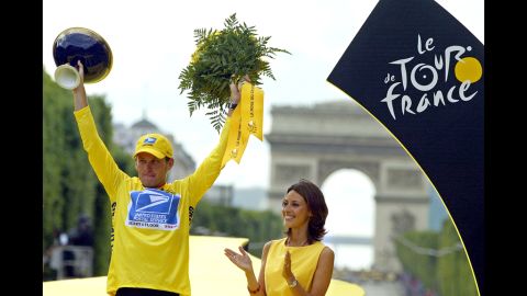 Armstrong celebrates on the podium after winning the Tour de France by 61 seconds in 2003.