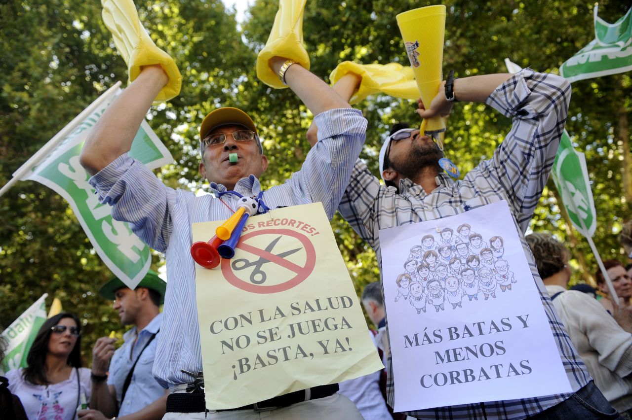 Health workers in Seville protest against government austerity measures on June 12, 2012. The campaigners display banners saying 'Don't play with health' and 'More gowns and fewer ties.'