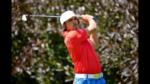Rickie Fowler of the United States hits his tee shot on the 13th hole during the first round.
