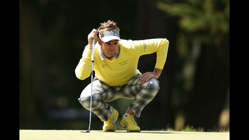Ian Poulter of England lines up a putt during the first round.