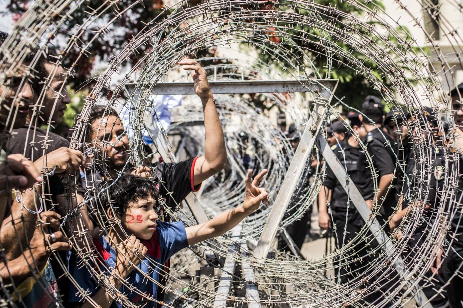 Protestors gesture towards military police through a barricade of barbed wire during a protest against presidential candidate Ahmed Shafik outside the Supreme Constitutional Court on Thursday.