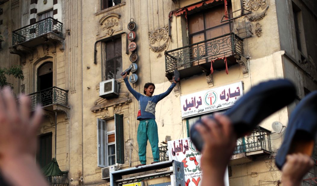 An Egyptian boy waves his shoes as he joins supporters of the Muslim Brotherhood in a protest in Cairo's Tahrir Square against Mubarak-era prime minister and presidential candidate Ahmed Shafik after Egypt's top court rejected on Thursday a law barring him from standing in a tense presidential poll runoff.