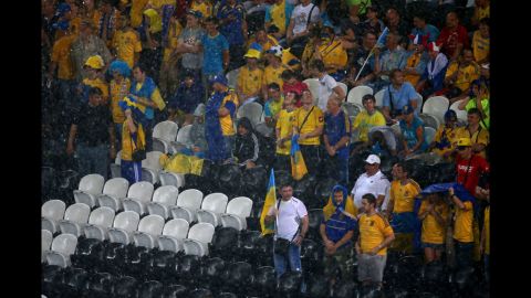 Fans endure the rains during the match between Ukraine and France.