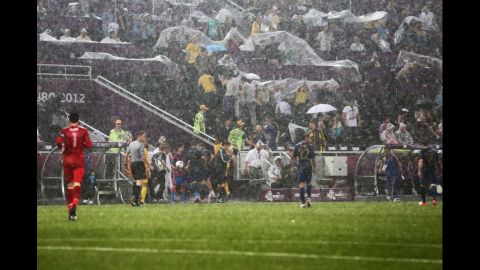 Players leave the field Friday after weather caused the Ukraine vs. France game to be suspended.