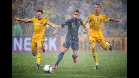 Yevhen Selin of Ukraine and Yevhen Khacheridi put pressure on Jeremy Menez of France during the group D match between Ukraine and France.