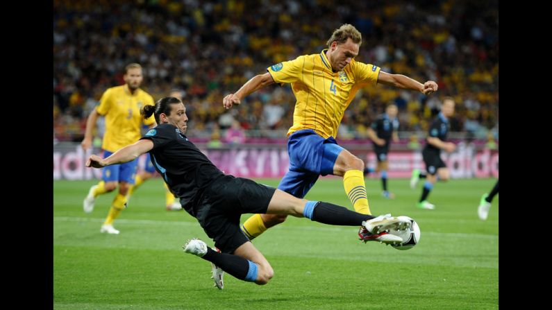 Andreas Granqvist of Sweden is tackled by Andy Carroll of England during the Sweden-England matchup.