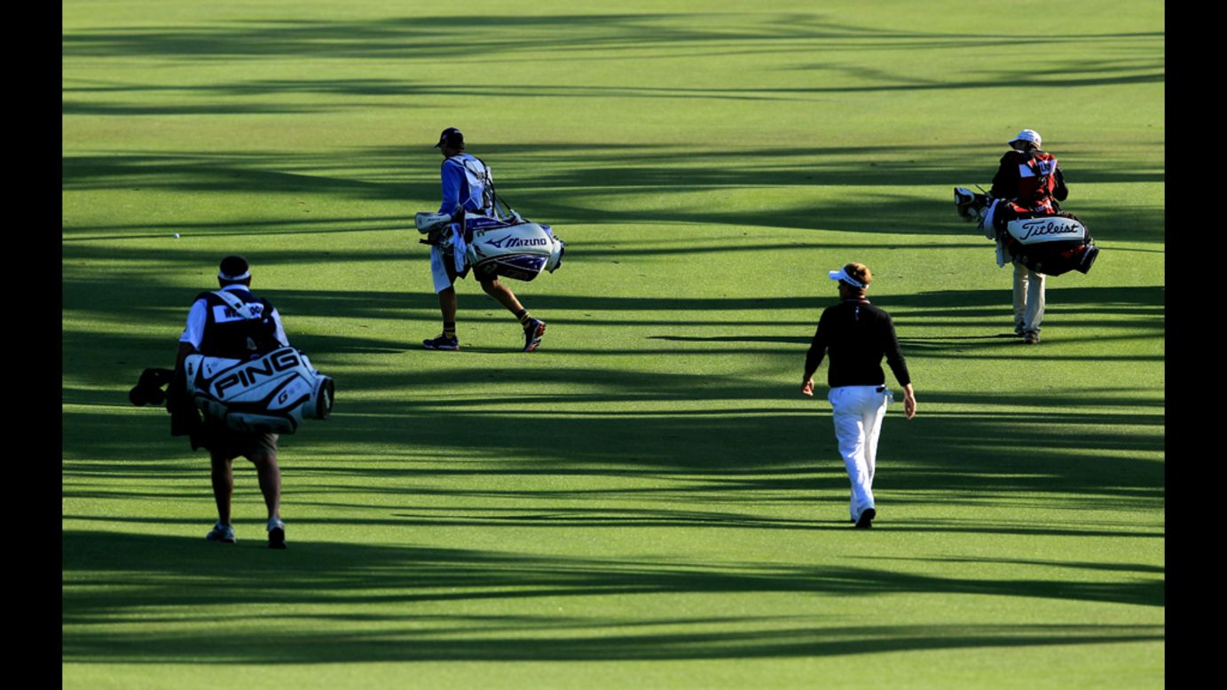 Luke Donald of England walks up a fairway with a group of caddies during the second round.