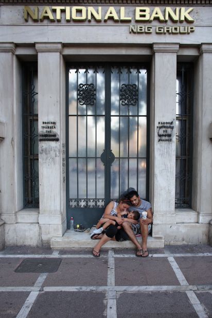 A family beg on the street in front of the National Bank in Athens. Greece is facing its fifth year of recession.