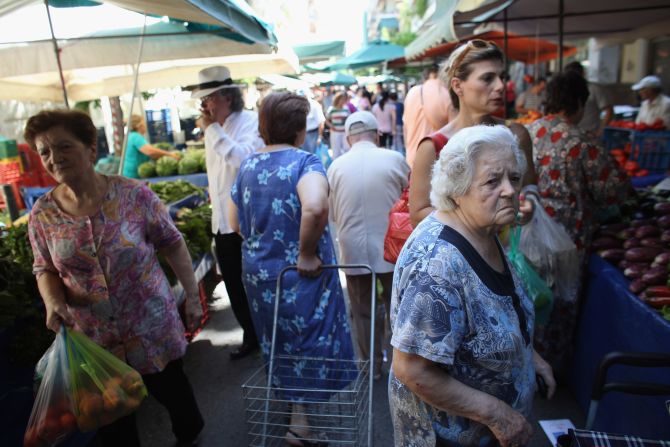 Greek people buy fruit and vegetables from a market in Omonoia on June 12, in Athens. After nearly three years of austerity measures, some Greeks say it is a struggle to continue feeding their families.