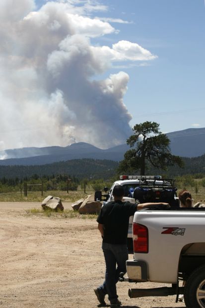 People watch smoke from the High Park Fire billow. The fire has consumed more than 50,000 acres and jumped Highway 14, prompting evacuations.