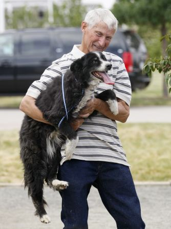 Resident Bill Janz reunites with his dog Abby on Wednesday. Abby had been at Janz's home when the fire started. She jumped into a fire truck as it approached the house, escaping the fire.