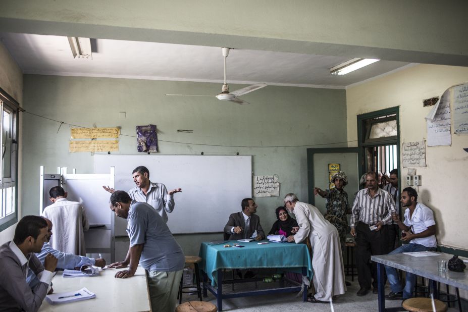 Election officials and an Egyptian soldier direct voters during the second stage of runoff presidential elections at a polling station in Giza.