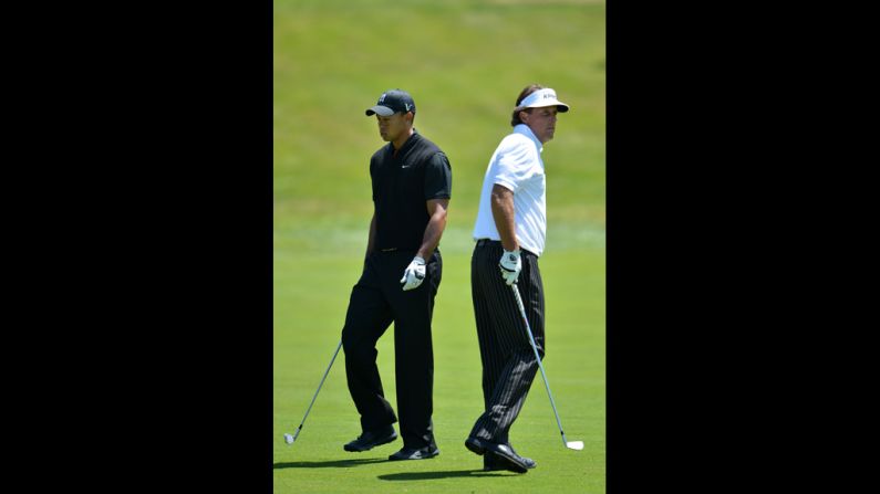 Tiger Woods and Phil Mickelson walk past one another during the second round.