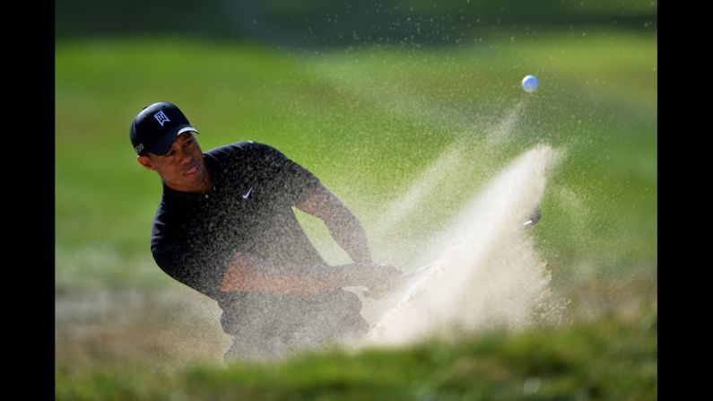  Tiger Woods plays a bunker shot on the 16th hole.